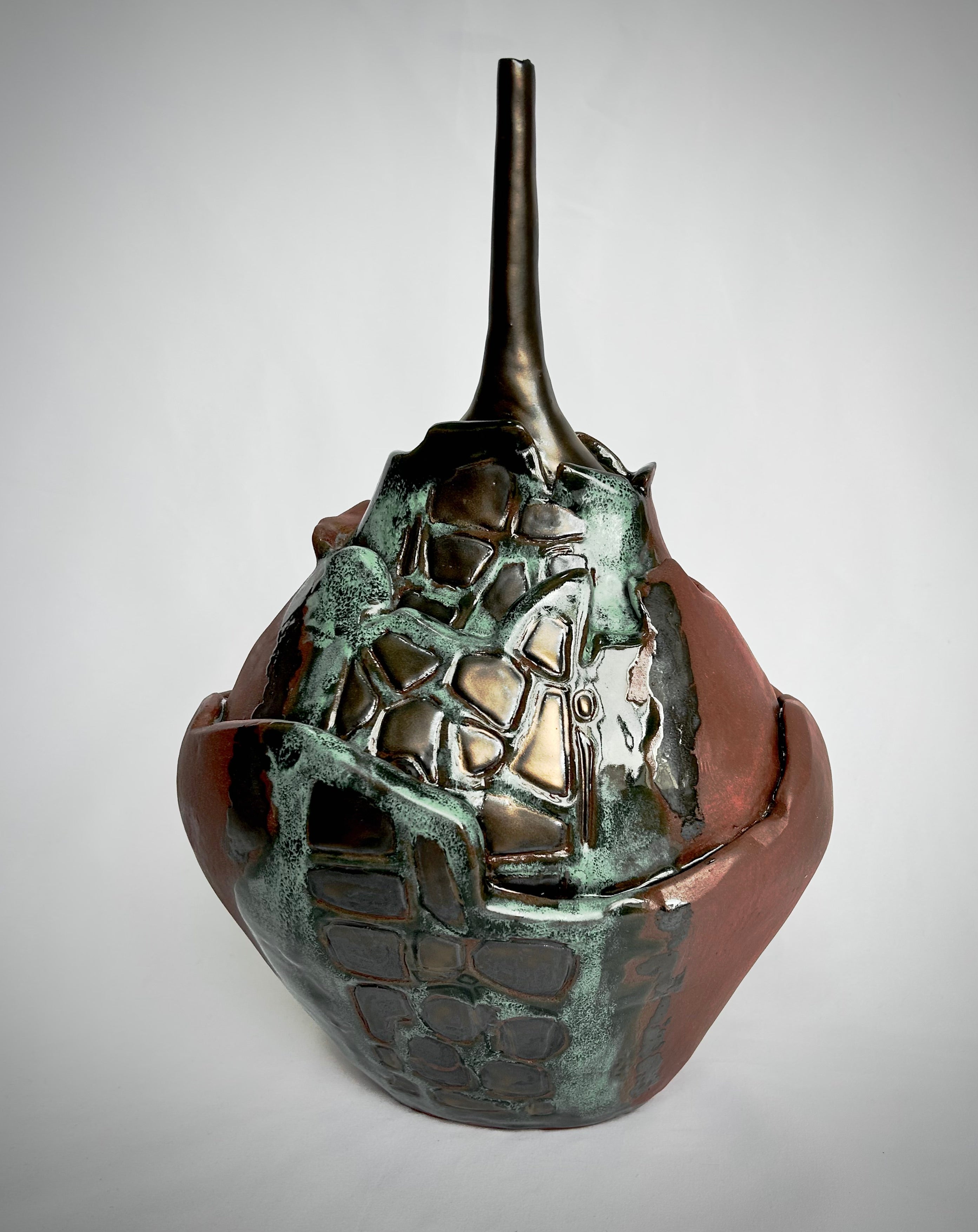 Bronze-colored organic-form sculpture on a gray background