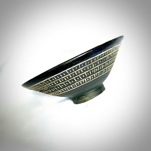 Ceramic bowl with african-style decorative patterns on a white background