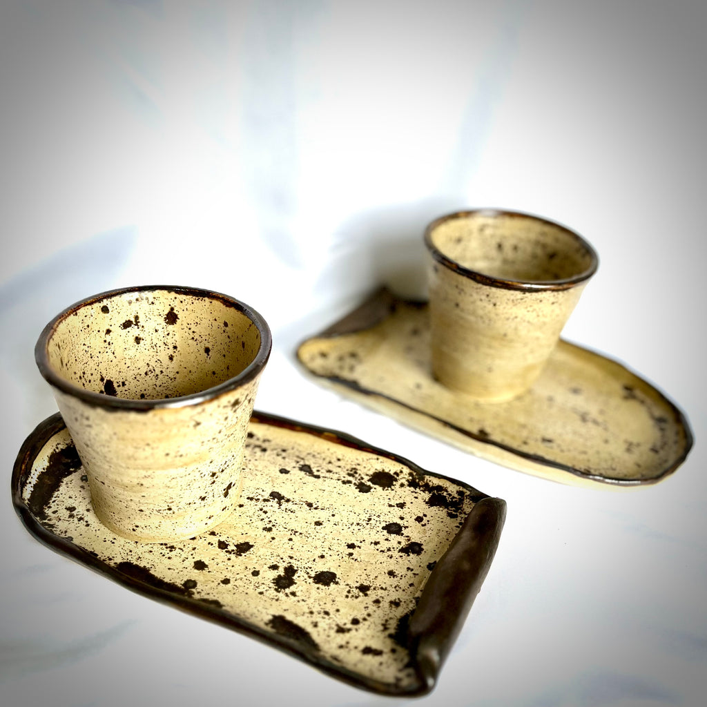 Speckled ceramic tray with two cups on a white background